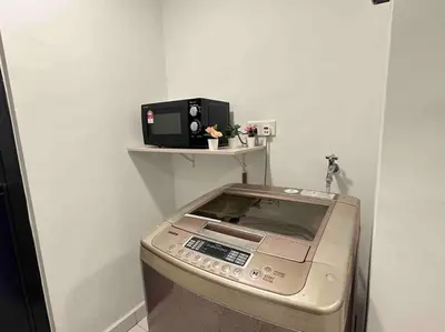 a fax machine in a room with a microwave at LM HomeyB 3BR Coastline Family Suite for 4-14 Pax with Nexflix & Coway Water Purifier in Tanjong Tokong