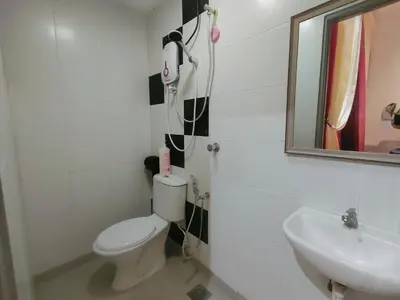 a bathroom with a toilet and a sink and a mirror at SKGARDEN HOME A1 BY IRAINBOW in Ipoh
