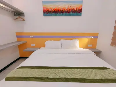 a bed in a room with a painting on the wall at C Boutique Townhouse Station 18 Ipoh By irainbow in Ipoh