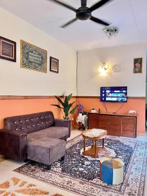 a living room with a couch and a flat screen tv at Rumah Tamu by Perdana Hōmes for Múslim only in Sungai Petani