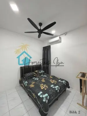a bedroom with a bed and a ceiling fan at Homestay Ibu in Lumut