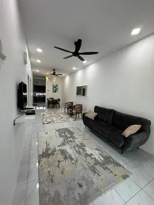 a living room with a couch and a ceiling fan at Homestay Ibu in Lumut