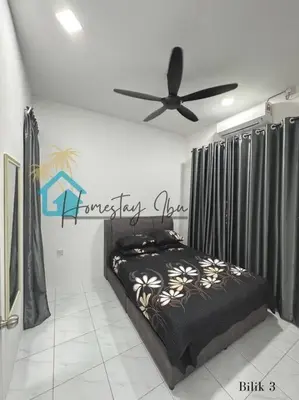 a bedroom with a bed and a ceiling fan at Homestay Ibu in Lumut