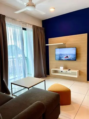a living room with a couch and a tv on a wall at Onsen Premium Hotspring Suite Sunway Tambun Ipoh in Tambun