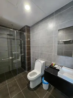 a bathroom with a toilet and a shower and a sink at Sunway onsen suite ipoh in Ipoh