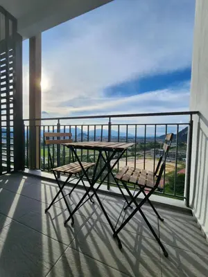 a table and chairs on a balcony with a view of the ocean at Sunway onsen suite ipoh in Ipoh
