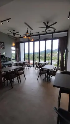 an empty room with tables and chairs and windows at Sunya Home G02 Raub Pahang in Raub