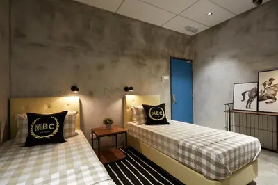 a bedroom with two beds and a blue door at M-Stay Hostel in Chemor