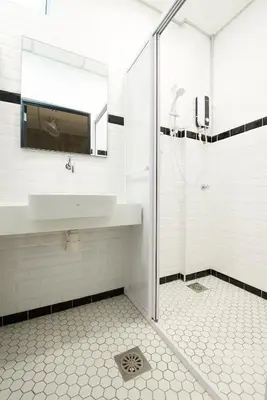 a white bathroom with a sink and a shower at M-Stay Hostel in Chemor