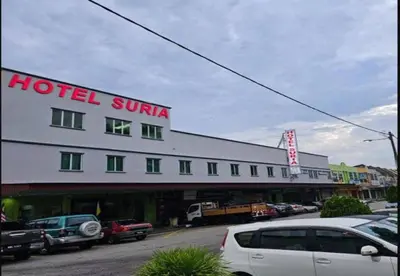 a hotel suriya with cars parked in a parking lot at JQ Suria Hotel in Lahat