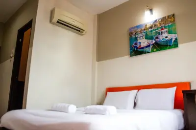 a bedroom with two beds and a painting on the wall at JQ Suria Hotel in Lahat