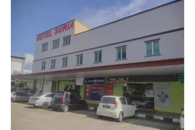 a building with cars parked in a parking lot at JQ Suria Hotel in Lahat