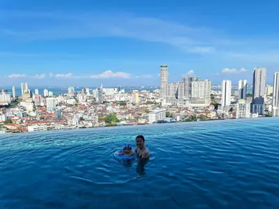 a man in the infinity pool of a city at Beacon Executive Suite - Skypool Penang View in George Town