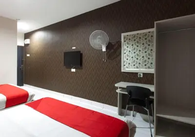 a bedroom with a bed and a desk and a tv at Hotel Pulai Ipoh in Ipoh