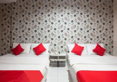 two beds in a room with red pillows at Hotel Pulai Ipoh in Ipoh