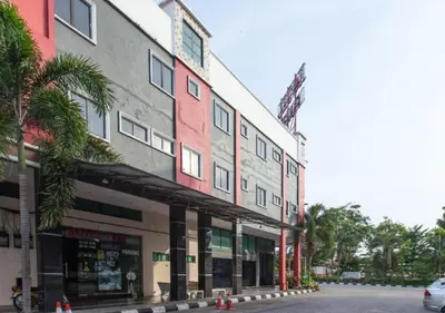 a building with a palm tree next to a street at Hotel Pulai Ipoh in Ipoh