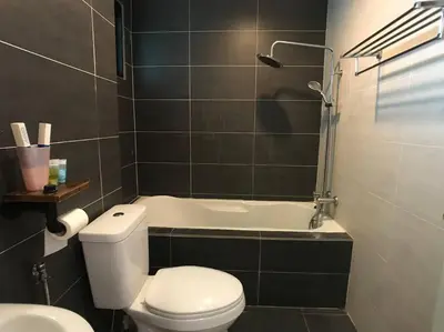 a bathroom with a toilet and a bath tub at 34zer0 Kinta Riverfront Suites 6pax in Ipoh