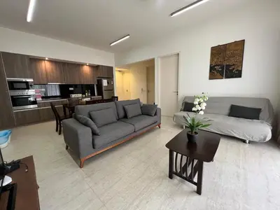 a living room with a couch and a table at By The Sea Ground Floor with Pool Facing 3A in Batu Ferringhi