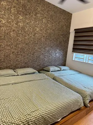 two beds in a bedroom with a wall at Adik Aisyah Black forest Cameron Highlands homestay For Muslim in Cameron Highlands