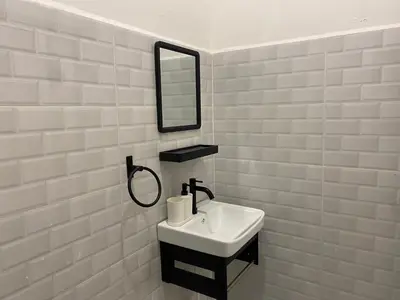 a white bathroom with a sink and a mirror at Dudu Guesthouse Ipoh in Ipoh