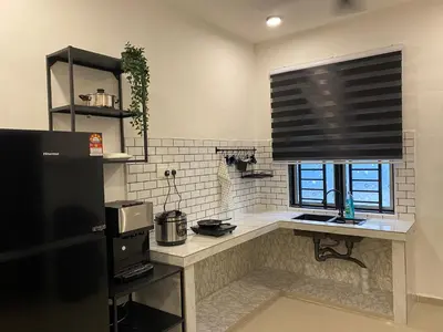a kitchen with a counter and a window with a window blind at Dudu Guesthouse Ipoh in Ipoh
