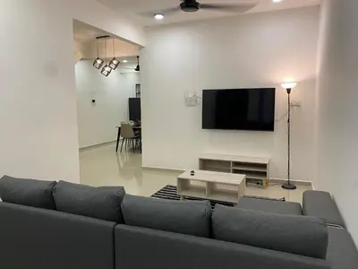 a living room with a couch and a flat screen tv at Dudu Guesthouse Ipoh in Ipoh