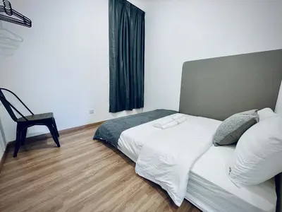 a bedroom with a bed and a chair in it at The Cove Hillside@Loft in Ipoh