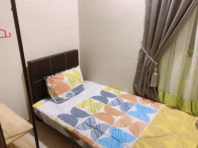 a small bed with a quilt and pillows on it at Ipoh Waterpark Pool View Homestay in Ipoh