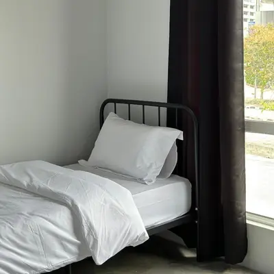 a bed with white sheets and a pillow next to a window at Be Right Back Loft - Bukit Mertajam in Bukit Mertajam