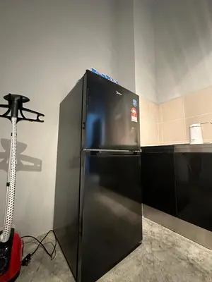 a black refrigerator in a kitchen with a camera at Be Right Back Loft - Bukit Mertajam in Bukit Mertajam