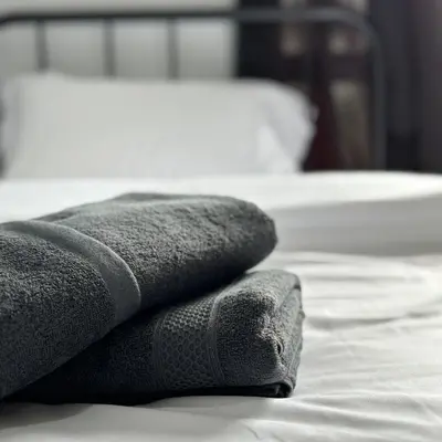 a pile of towels sitting on top of a bed at Be Right Back Loft - Bukit Mertajam in Bukit Mertajam