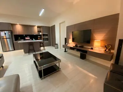a living room with a large television and a couch at By The Sea Side Seaview and Mountain View 252 in Batu Ferringhi