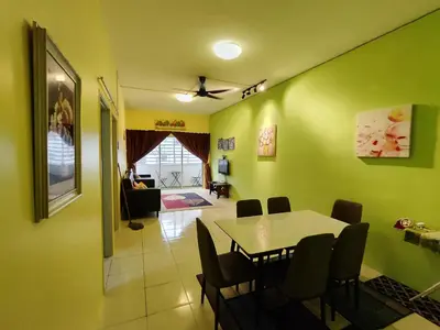 a dining room and living room with a table and chairs at Nanalacy Homestay ISLAM SAHAJA in Tanah Rata