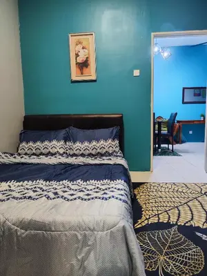 a bedroom with a bed with a blue wall at Nanalacy Homestay ISLAM SAHAJA in Tanah Rata