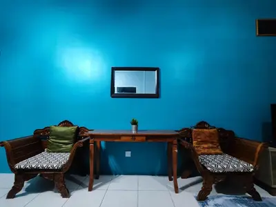 a table with two chairs and a mirror on a blue wall at Nanalacy Homestay ISLAM SAHAJA in Tanah Rata