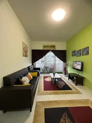 a living room with a black couch and a tv at Nanalacy Homestay ISLAM SAHAJA in Tanah Rata