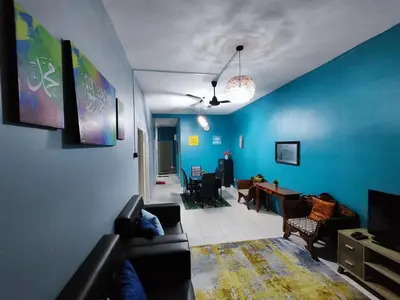 a living room with a couch and a blue wall at Nanalacy Homestay ISLAM SAHAJA in Tanah Rata