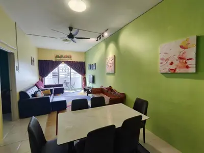 a living room with green walls and a table and chairs at Nanalacy Homestay ISLAM SAHAJA in Tanah Rata