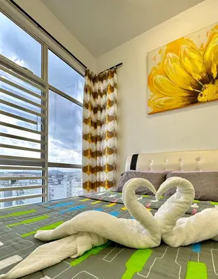 two swans laying on a bed in a bedroom at Casa Ipoh Homestay by Comfort Home in Chemor