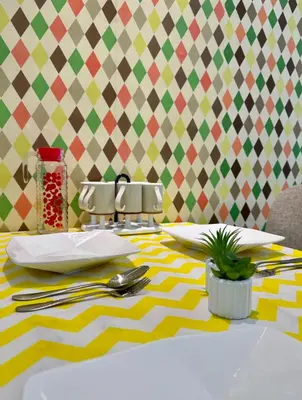 a dining table with a yellow and white table cloth at Casa Ipoh Homestay by Comfort Home in Chemor