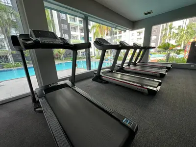 a row of treadmills in a gym with a pool at 7&9 Manhattan Condominium Ipoh in Ipoh