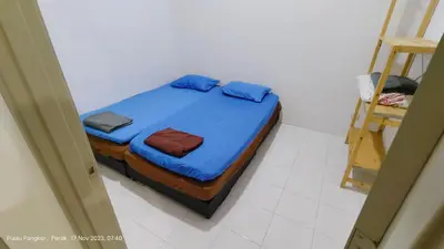 a bedroom with a bed with blue sheets and a ladder at 3 Rooms Apartment - Near Beach in Kampong Sungai Udang