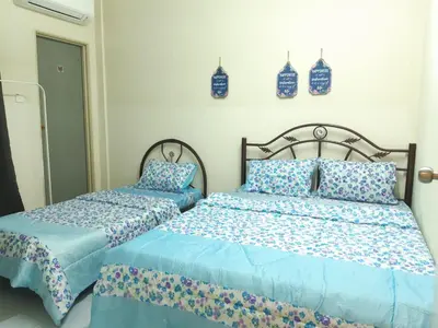 two beds sitting next to each other in a bedroom at Ammar Homestay Gua Musang in Gua Musang