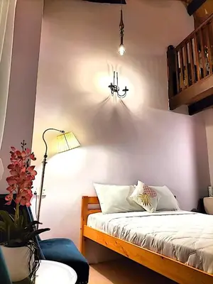 a bedroom with a bed with a light and a lamp at Le Meilleur in George Town