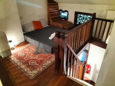 a small bedroom with a bed and a staircase at Le Meilleur in George Town