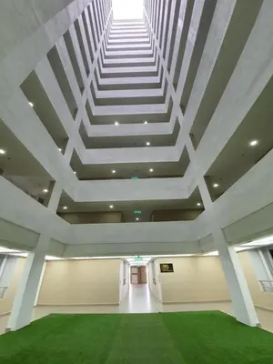 a large room with a white ceiling and a green carpet at A Modern & Homely Studio with Pool and Gym in Kampar