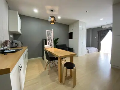 a kitchen with a wooden table and a dining room at A Modern & Homely Studio with Pool and Gym in Kampar
