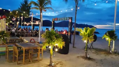 a party on the beach at night with palm trees at By The Sea with Direct Seaview level7 in Batu Ferringhi