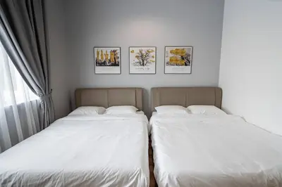two beds in a room with pictures on the wall at Green Terrace at Quintet (3BR/ 8 Pax） in Tanah Rata