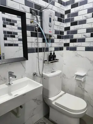 a bathroom with a shower and a toilet and a sink at A One Holiday Apartment - PRO in Tanah Rata